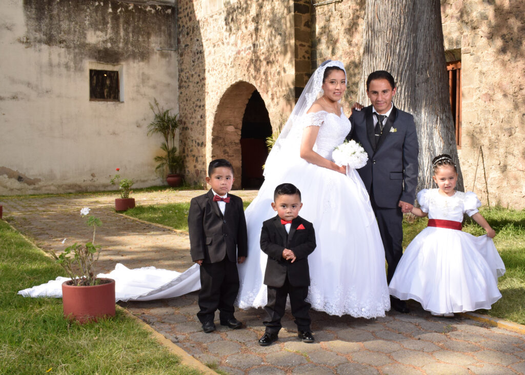 foto de novios con niños, tomada por Zina fotografía en museo virreynal de Zinacantepec, vestido de novia largo